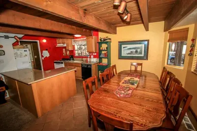 a kitchen with a wooden table and a dining room at Family Fun House in Big Bear Lake
