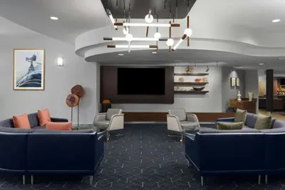 a waiting room with couches and a flat screen tv at Courtyard Los Angeles Burbank Airport in Burbank