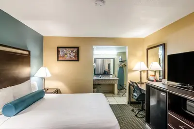 a hotel room with a bed and a desk at Glenridge Inn Glendale - Pasadena in Glendale