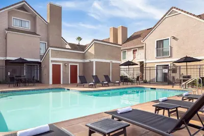 a swimming pool with lounge chairs and a building at Residence Inn by Marriott Long Beach in Long Beach