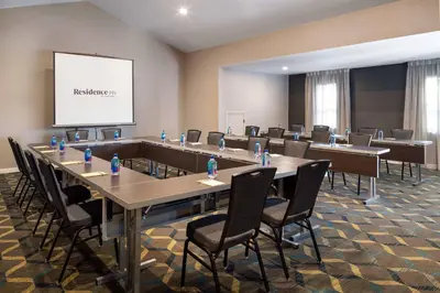 a conference room with tables and chairs and a screen at Residence Inn by Marriott Long Beach in Long Beach