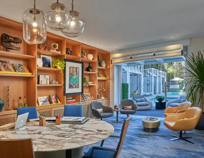 a living room with a table and chairs and a room with a window at Viceroy Santa Monica in Los Angeles
