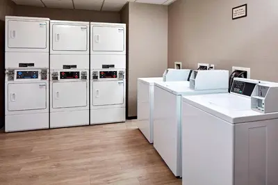 a laundry room with white washers and dryers at Residence Inn Los Angeles LAX/Manhattan Beach in Manhattan Beach