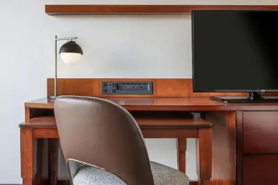 a desk with a television and a chair in a room at Courtyard by Marriott Los Angeles Pasadena/Monrovia in Monrovia