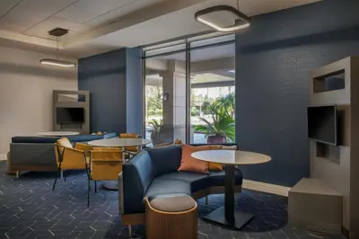 a living room with a couch and tables and chairs at Courtyard by Marriott Los Angeles Pasadena/Monrovia in Monrovia