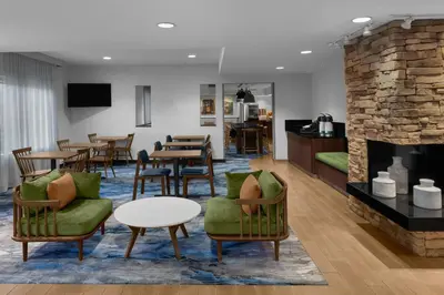 a living room with chairs and tables and a fireplace at Fairfield Inn by Marriott Santa Clarita Valencia in Santa Clarita