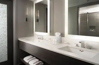 a bathroom with two sinks and a large mirror at Warner Center Marriott Woodland Hills in Woodland Hills