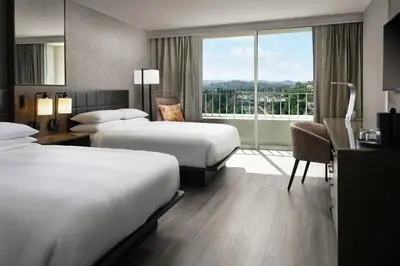 a hotel room with two beds and a desk and a window at Warner Center Marriott Woodland Hills in Woodland Hills