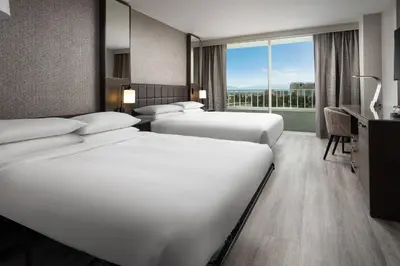 a hotel room with three beds and a window at Warner Center Marriott Woodland Hills in Woodland Hills