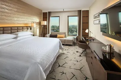 a hotel room with a large bed and a desk at Sheraton Los Angeles San Gabriel in San Gabriel
