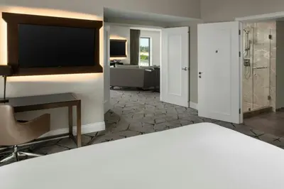 a living room with a television and a bathroom at Sheraton Los Angeles San Gabriel in San Gabriel