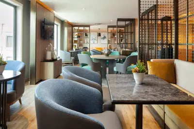 a dining room with blue chairs and tables and tablesktop at Sheraton Los Angeles San Gabriel in San Gabriel