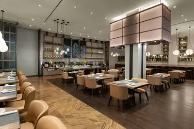a restaurant with tables and chairs and a bar at Sheraton Los Angeles San Gabriel in San Gabriel