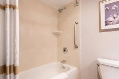 a bathroom with a white tub and a toilet at Bakersfield Marriott at the Convention Center in Bakersfield
