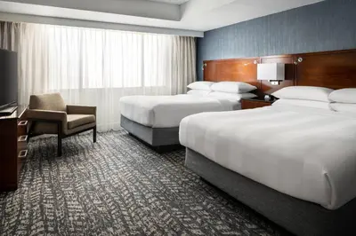 a hotel room with two beds and a chair at Bakersfield Marriott at the Convention Center in Bakersfield