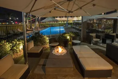 a patio with a fire pit and tables and an umbrella at Bakersfield Marriott at the Convention Center in Bakersfield