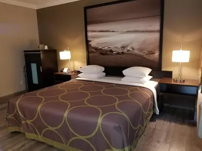 a hotel room with a large bed with two lamps at Super 8 by Wyndham Los Angeles-Culver City Area in Los Angeles