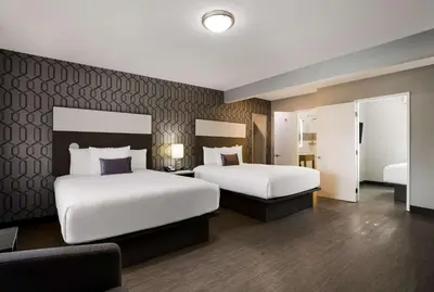 a hotel room with two beds and a couch at Sunset West Hotel, SureStay Collection By Best Western in Los Angeles