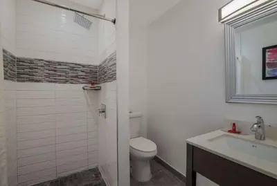 a white bathroom with a toilet and a sink at Sunset West Hotel, SureStay Collection By Best Western in Los Angeles