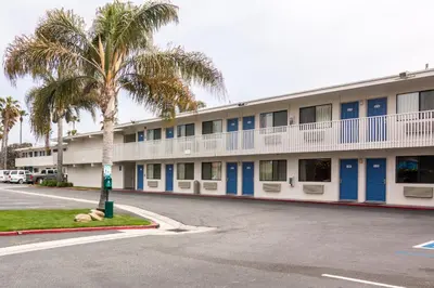a building with palm trees in front of a street at Motel 6-Ventura, CA - Beach in Ventura