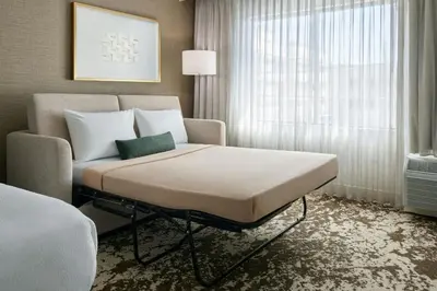 a bed and a chair in a room at Courtyard by Marriott Los Angeles Pasadena Old Town in Pasadena