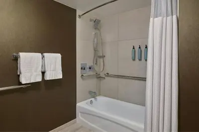a bathroom with a shower and a white bath tub at Courtyard by Marriott Los Angeles Pasadena Old Town in Pasadena