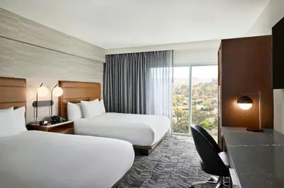 a hotel room with two beds and a window at Courtyard Los Angeles Sherman Oaks in Sherman Oaks