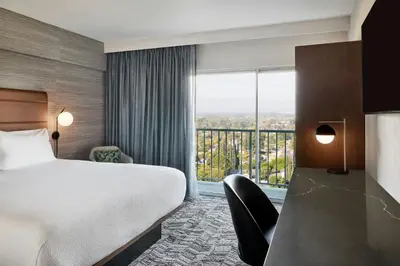 a hotel room with a bed and a large window at Courtyard Los Angeles Sherman Oaks in Sherman Oaks