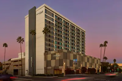 a large building with palm trees in front of it at Courtyard Los Angeles Sherman Oaks in Sherman Oaks