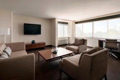 a living room with couches and a flat screen tv at Fullerton Marriott at California State University in Fullerton