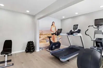 a woman in a gym with a painting on the wall at Clarion Pointe Ridgecrest near China Lake Naval Station in Ridgecrest