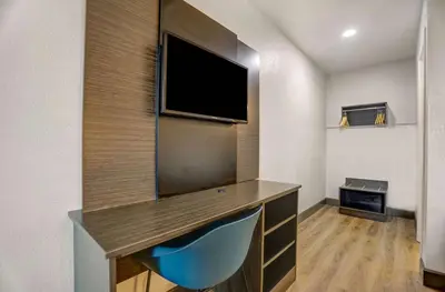 a room with a flat screen tv and a desk at Motel 6-San Bernardino, CA - South in San Bernardino