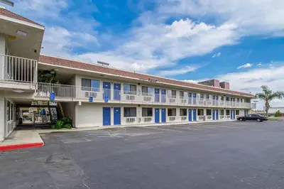 a large building with blue windows and a parking lot at Motel 6-Bakersfield, CA - Airport in Bakersfield