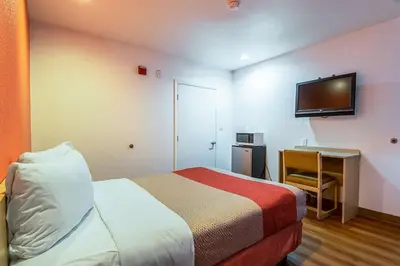 a hotel room with a bed and a flat screen tv at Motel 6-Bakersfield, CA - Airport in Bakersfield