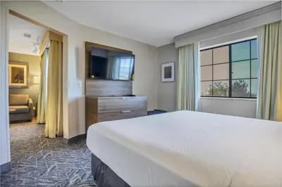 a hotel room with a large bed and a television at Best Western Hesperia-Victorville Suites in Hesperia