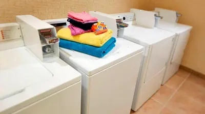 a pile of towels sitting on top of a washing machine at Best Western Hesperia-Victorville Suites in Hesperia