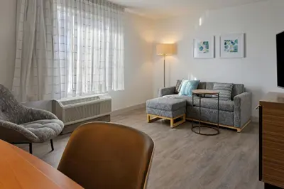 a living room with chairs and a couch and a table at TownePlace Suites by Marriott Ontario Airport in Rancho Cucamonga