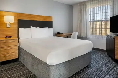 a hotel room with a large bed and a television at TownePlace Suites by Marriott Ontario Airport in Rancho Cucamonga