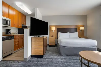a hotel room with a bed and a flat screen tv at TownePlace Suites by Marriott Ontario Airport in Rancho Cucamonga