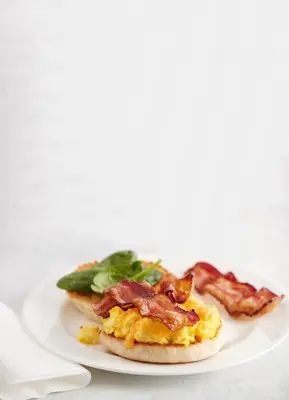 a plate with a breakfast sandwich with bacon on it at Residence Inn by Marriott Ontario Airport in Ontario
