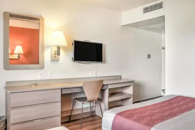 a hotel room with a desk with a tv and a bed at Motel 6-Mojave, CA in Mojave