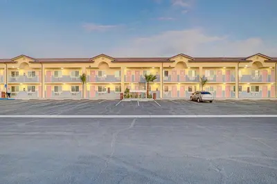 a large hotel with a car parked in a parking lot at Welcome Inn San Bernardino/ Colton in Colton