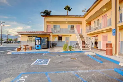 a parking lot in front of a building with a gas station at Welcome Inn San Bernardino/ Colton in Colton
