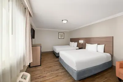 a hotel room with two beds and a couch at Solara Inn and Suites in Anaheim