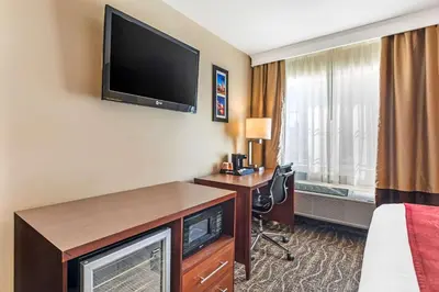 a hotel room with a bed and a desk with a television at Comfort Inn Monterey Park - Los Angeles in Monterey Park