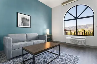 a living room with a couch and a table and a window at Four Points by Sheraton, Ontario-Rancho Cucamonga in Rancho Cucamonga