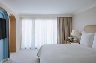a bedroom with a white bed and a large window at Regent Santa Monica Beach in Los Angeles