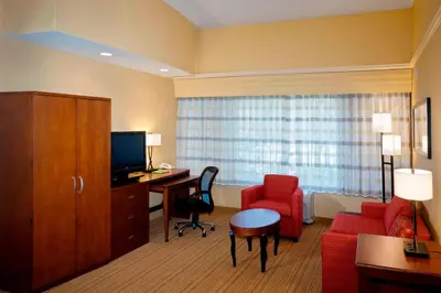 a hotel room with a desk and a red chair at Courtyard Ventura Simi Valley in Simi Valley