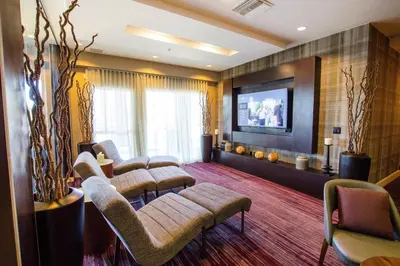 a waiting room with chairs and a flat screen tv at Courtyard Ventura Simi Valley in Simi Valley