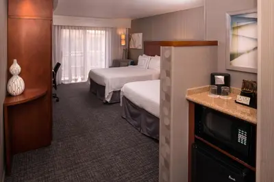 a hotel room with two beds and a television at Courtyard by Marriott Thousand Oaks Ventura County in Thousand Oaks